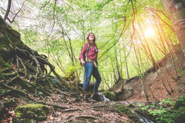 güzel ormanda sırt çantası ile gülümseyen genç kadının düşük açı görünümü 