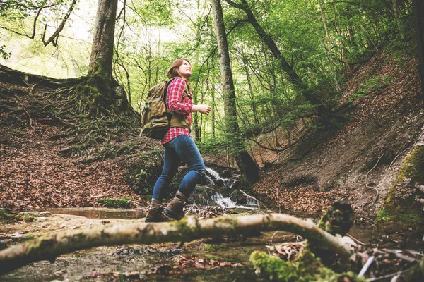 ormanda sırt çantası yürüyüş ile güzel gülümseyen genç kadın düşük açı görünümü  