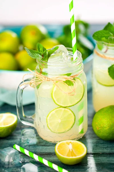 lemonade with lime and mint in mason jars on wooden table
