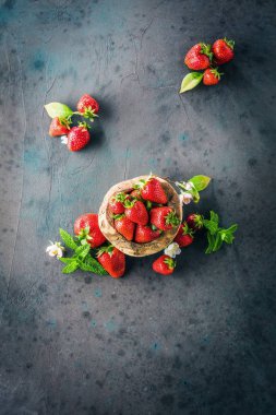 gri arka planda taze olgun çilek ve çiçekler üst görünümü