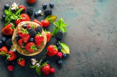 yeşil nane yaprakları ve gri arka planda çiçekler ile taze çilek üst görünümü 