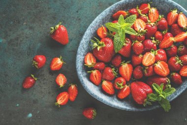 taze olgun çilek ve nane yaprakları ile kase üst görünümü 