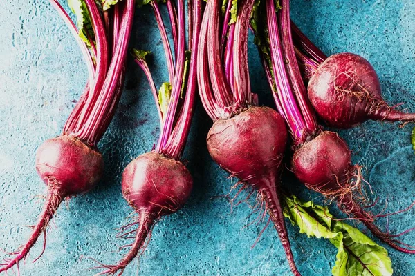 Mavi yüzeyde taze pişmemiş pancarların yakın plan görüntüsü