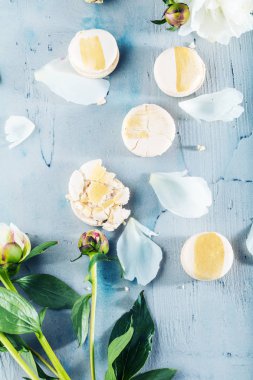 ahşap yüzeyde makaron ve beyaz şakayık çiçeklerüst görünümü   