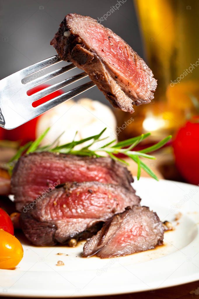 close-up view of delicious grilled venison steak on fork