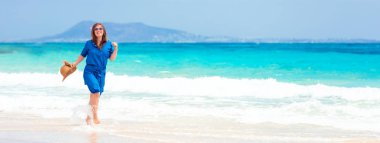 Tropik plaj tatilizevk mavi elbiseli mutlu gezgin kadın