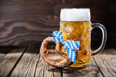 Bir bardak bira ve ahşap arka planda lezzetli kraker.