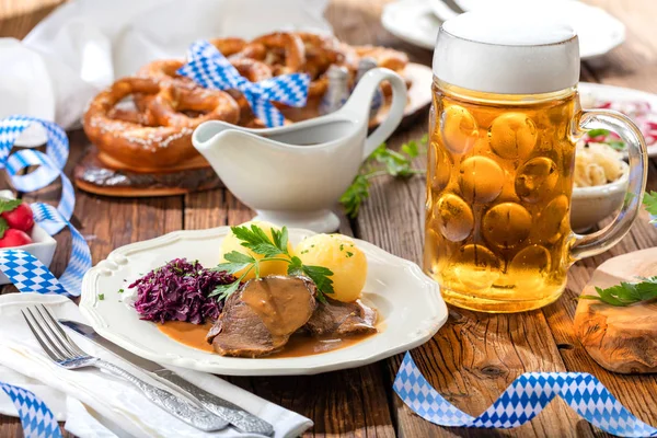 特写的美味肉类与土豆和啤酒杯在桌子上 啤酒节的概念 — 图库照片