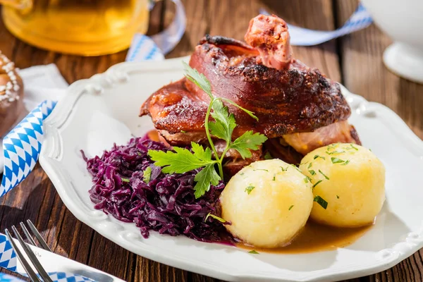 テーブルの上にジャガイモとおいしいシュヴァンシャクまたはドイツの豚のナックルのクローズアップビュー — ストック写真