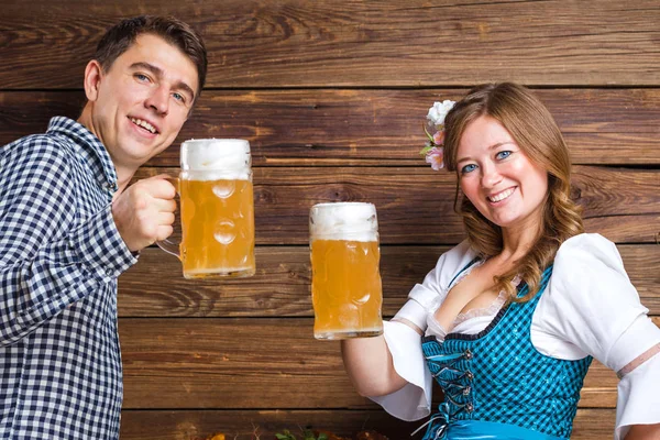 Šťastný Mladý Pár Sklenicemi Piva Usmívající Dřevěné Pozadí Oktoberfestu — Stock fotografie