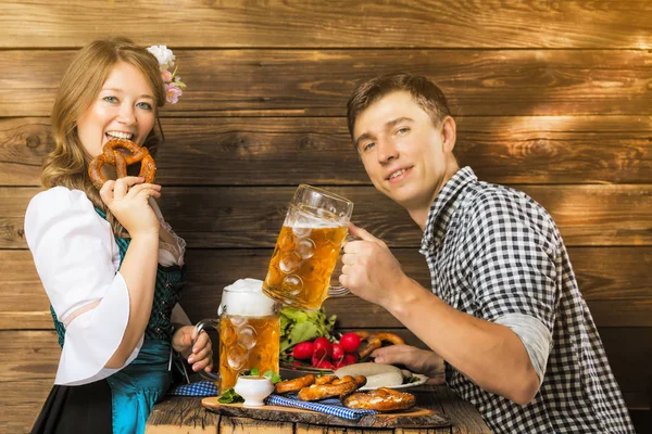 Glückliches Junges Paar Trinkt Bier Und Isst Leckeres Essen Holztisch — Stockfoto