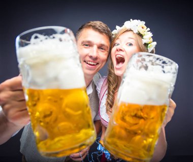 mutlu genç arkadaşlar bira bardak tutan ve kamera gülümseyen