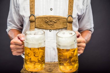 oktoberfest bira kupaları tutan geleneksel Bavyera giysileri adam orta bölümü