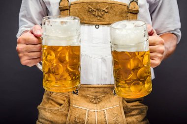 oktoberfest bira kupaları tutan geleneksel Bavyera giysileri adam orta bölümü