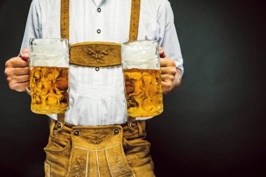 Oktoberfest bira kupaları tutan geleneksel Bavyera giysileri adam kırpılmış atış