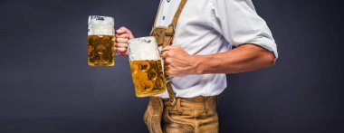 Oktoberfest bira kupaları tutan geleneksel Bavyera giysileri adam kırpılmış atış