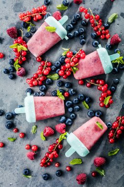 gri yüzeyde lezzetli tatlı buz lollies ve taze olgun çilek üst görünümü