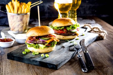 taze gurme hamburgerler, patates kızartması ve masada bira gözlük yakın çekim görünümü    