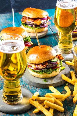 taze gurme hamburgerler, patates kızartması ve masada bira gözlük yakın çekim görünümü   