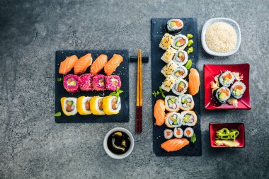 Tahtalarda yemek çubukları ve soya sosuyla nefis suşi seti.