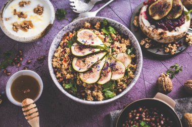 Masa Camembert, peynir, kuskus üzerinde incir, nar tohumları ve fındık ile sağlıklı çanak üst görünümü