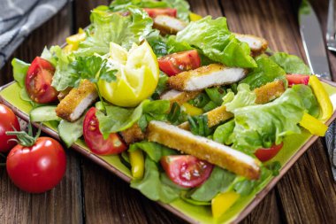 ahşap masada marul, kiraz domates ve ızgara tavuk ile lezzetli taze salata yakın görüş