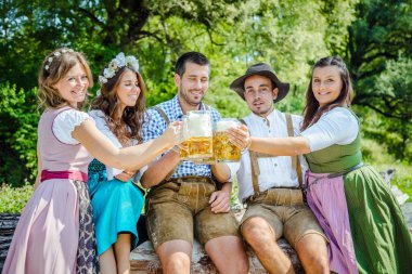 Bavyera kostümleri beş arkadaş bira bardakclinking ve birlikte açık havada eğlenmek  