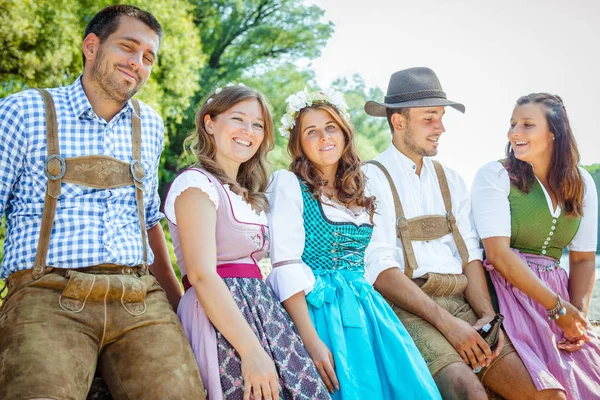 Bavyera kostümleri beş mutlu genç arkadaş birlikte eğlenmek ve kamera açık gülümseyerek  