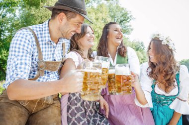 Bavyera kostümleri mutlu arkadaşlar bira gözlük clinking ve birlikte açık havada eğlenmek, oktoberfest kavramı