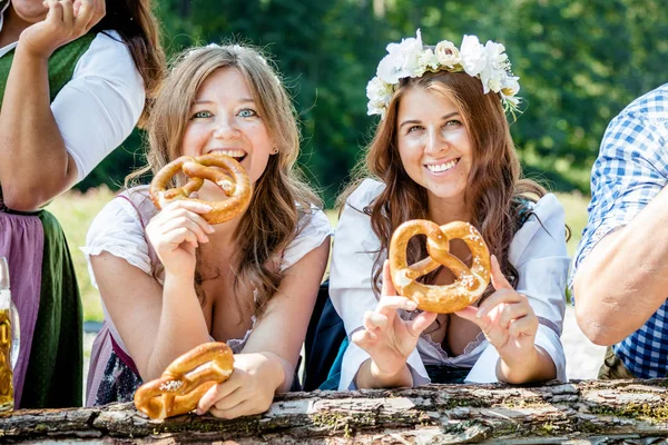 Boldog Női Barátok Bajor Jelmezben Perecet Esznek Sört Isznak Együtt — Stock Fotó