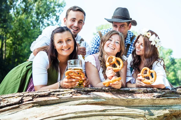 Lyckliga Unga Vänner Bayerska Kostymer Håller Med Pretzels Och Leende — Stockfoto