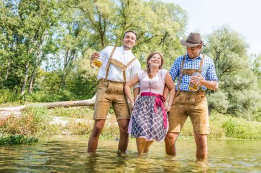 Bavyera kostümleri mutlu genç arkadaşlar bira gözlük tutan ve eğlenmek açık havada, oktoberfest kavramı