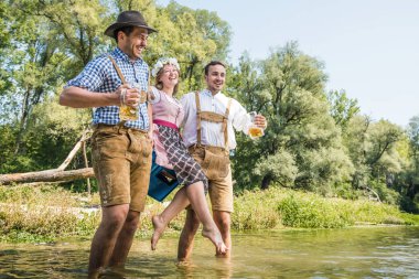 Bavyera kostümleri mutlu genç arkadaşlar bira gözlük tutan ve açık yürüyüş, oktoberfest kavramı 