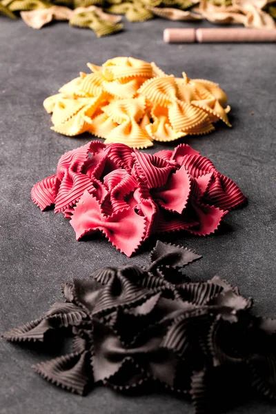 close-up view of uncooked pasta in colors of german flag on black background