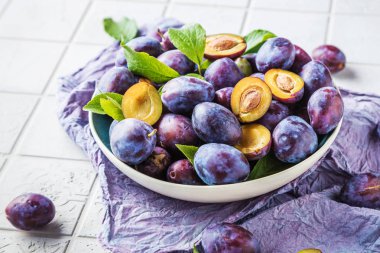 masada taze olgun erik ve yeşil yaprakları ile plaka yakın çekim görünümü 