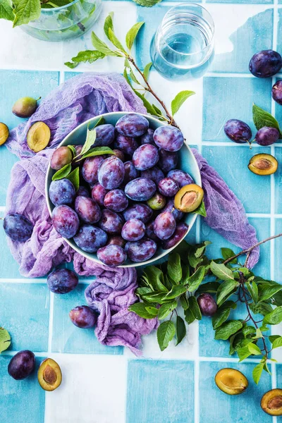 Top View Fresh Ripe Plums Bowl Green Leaves Table — Stock Photo, Image