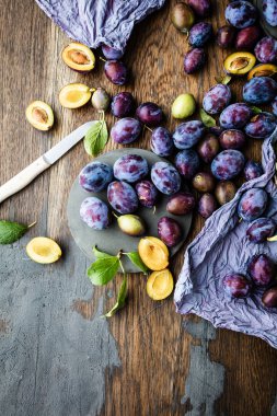 ahşap masa üzerinde taze olgun erik ve bıçak üst görünümü