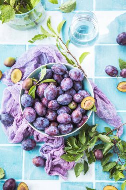 kasede yeşil yaprakları ile taze olgun erik üst görünümü