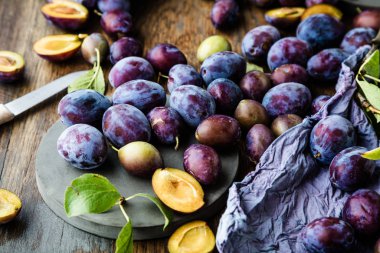 ahşap masada yaprakları ile taze olgun lezzetli erik üst görünümü   