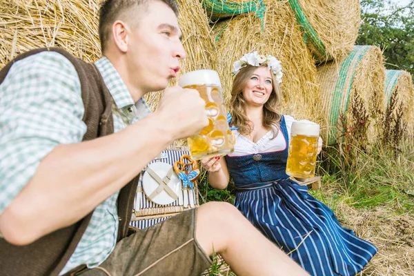Happy Young Couple Bavarian Costumes Sitting Straw Bales Drinking Beer — Stock Photo, Image