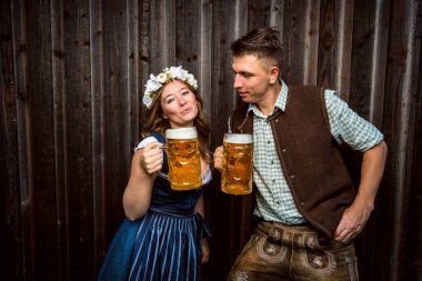 bira bardakları tutan Bavyera kostümleri mutlu genç çift, oktoberfest kavramı