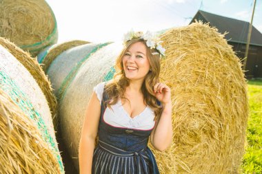 Bavyera güneşli bir günde saman balyaları yakınında geleneksel Bavyera giysileri güzel gülümseyen genç