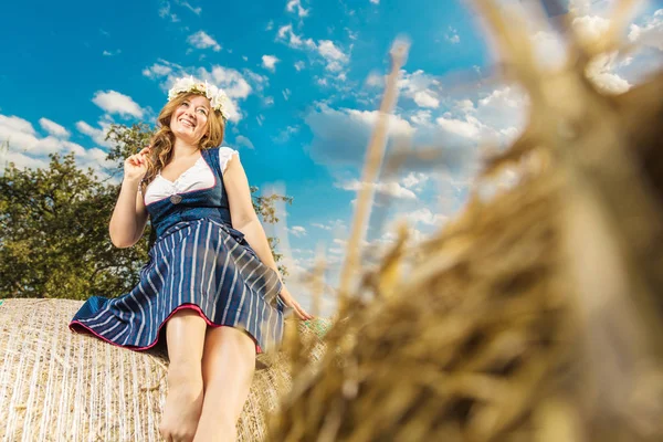 在阳光明媚的日子里 穿着传统巴伐利亚服装的妇女 选择性地聚焦在草捆上 — 图库照片