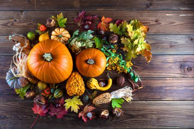Tahta yüzeyde taze kabak, mısır, domates, kestane ve sonbahar yapraklarının üst görüntüsü 