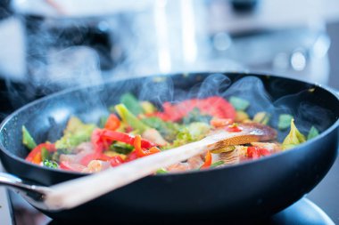 Modern elektrikli fırında sebze ve tavuğun yakın plan görüntüsü.