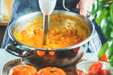 masada malzemelerle taze kabak çorbası püresi hazırlayan kişinin kısmi görünümü 