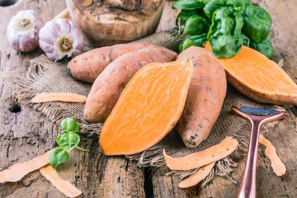 ahşap masada fesleğen yaprakları ile lezzetli sağlıklı bütün tatlı patates yakın çekim görünümü