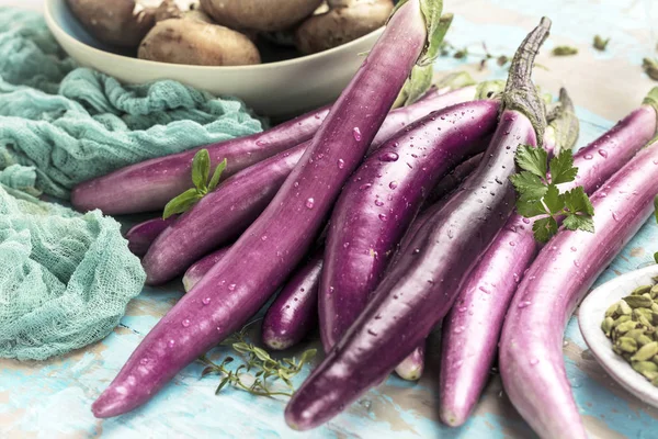 top view of fresh purple japanese eggplants on rustic colored wooden background