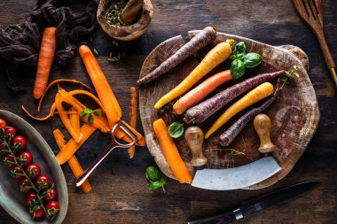 ahşap masada taze çiğ gökkuşağı havuç ve domates üst görünümü