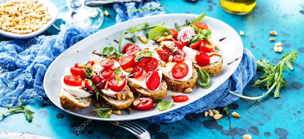 close-up view of delicious Italian bruschetta with chopped tomatoes, basil and mozzarella on grilled crusty bread